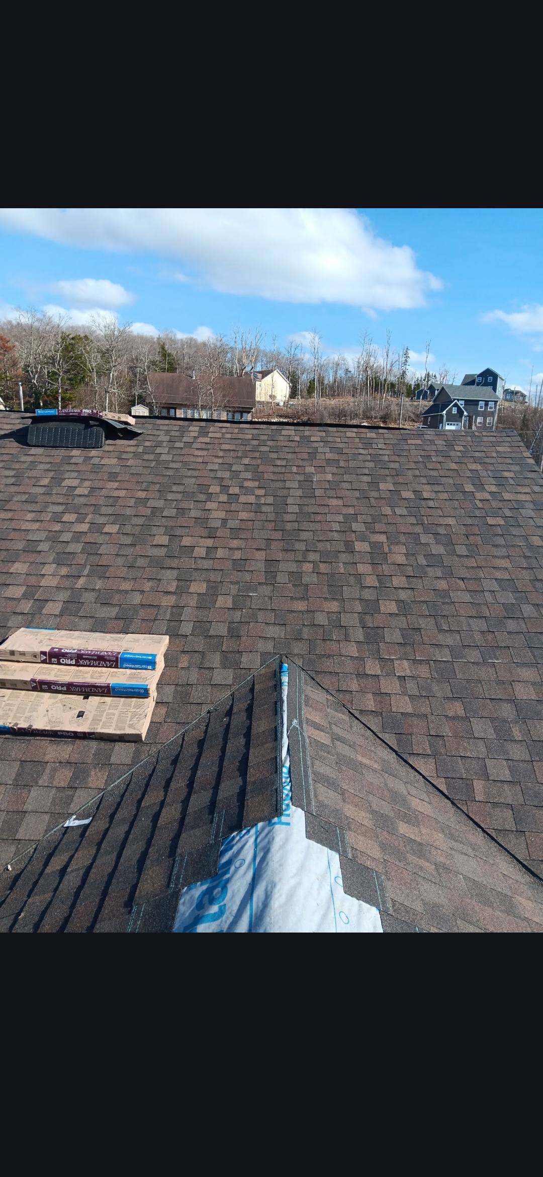 Newly installed CertainTeed Landmark Pro shingle roof with shingle bundles staged on top, by Maxwell Roofing in the Halifax area, Nova Scotia